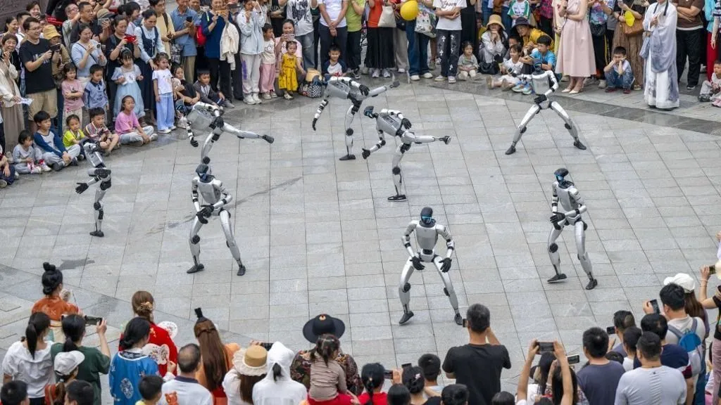 A képen Humanoid robotok Kínában, egy látványos bemutató keretében(260503) -- BEIJING, May 3, 2026 (Xinhua) -- A drone photo taken on May 2, 2026 shows robots performing at a park in Wuzhou City, south China's Guangxi Zhuang Autonomous Region. People across China stepped out to fully enjoy their leisure time during the ongoing May Day holiday. (Photo by He Huawen/Xinhua) (Photo by He Huawen / Xinhua via AFP)
