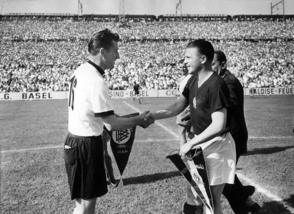 Hungary's team captain Ferenc Puskas (R) and German team captain Fritz Walter exchange pennants prior to the 1954 FIFA World Cup match in Basel on June 20th. Hungary beats Germany 8:2. (Photo by dpa INP / A0009_dpa_inp / dpa Picture-Alliance via AFP)
