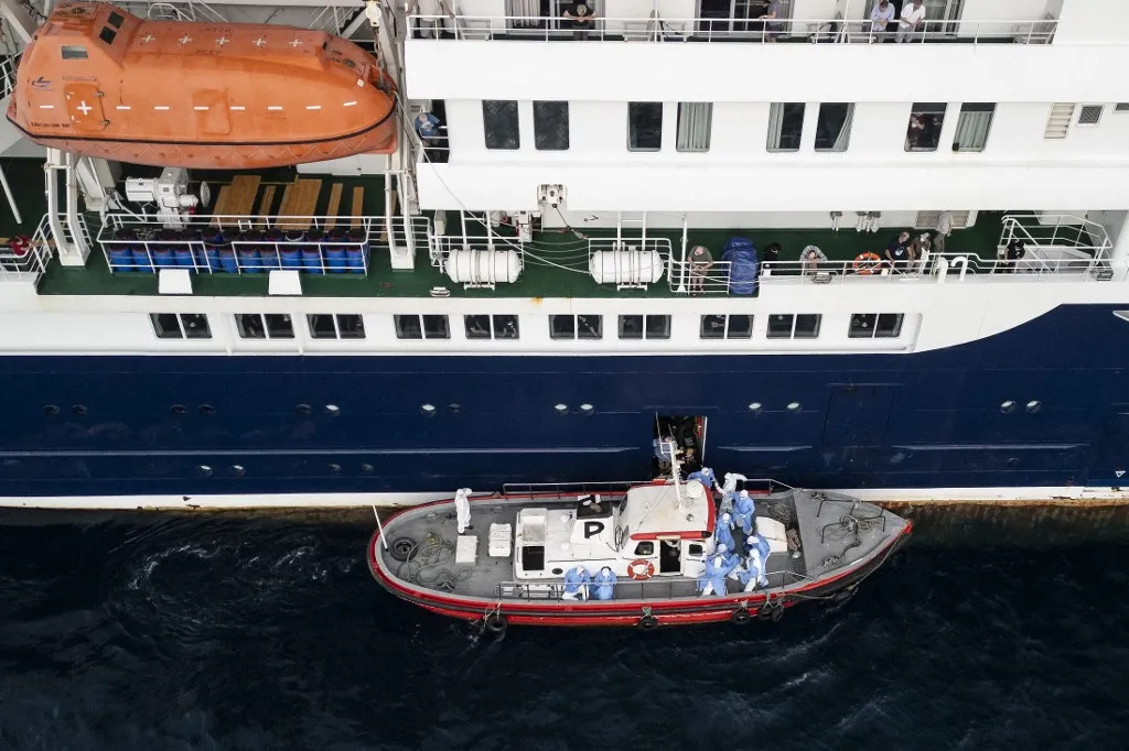 This aerial view shows health personnel assisting patients onto a boat from the cruise ship MV Hondius, while stationary off the port of Praia, the capital of Cape Verde, on May 6, 2026. Evacuations were taking place on May 6, 2026 from a cruise ship stricken with a deadly outbreak of hantavirus, the World Health Organization said, as experts confirmed a rare strain that can be transmitted between humans.
Three people, two crew members and one other person, thought to be infected with the virus were being taken off the MV Hondius, anchored off Cape Verde, the WHO said. (Photo by AFP)