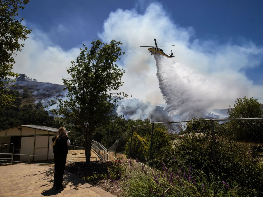 Erdőtűz, Kalifornia, ErdőtűzKalifornia, 2026.05.19., Simi Valley, 2026. május 19.
Vizet dob le egy helikopter a lángoló növényzetre a kaliforniai Simi Valley településnél 2026. május 18-án, amikor erdőtüzek pusztítanak Kalifornia déli részén.
MTI/AP/Etha