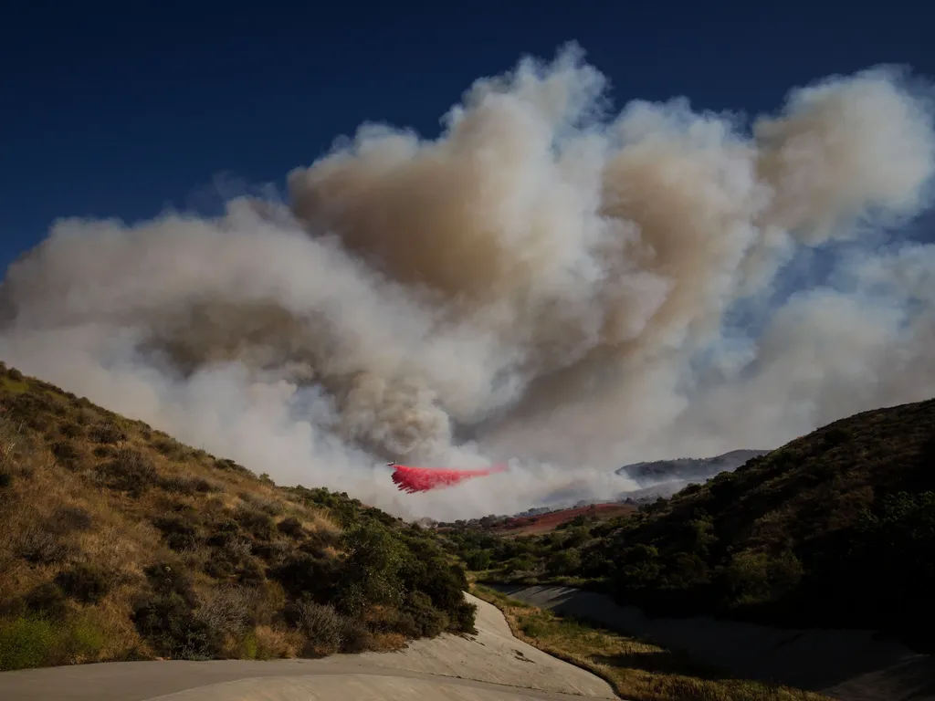 Erdőtűz, Kalifornia, ErdőtűzKalifornia, 2026.05.19., Simi Valley, 2026. május 19.
Tűzgátló anyagot dob le egy repülőgép a lángoló növényzetre a kaliforniai Simi Valley településnél 2026. május 18-án.
MTI/AP/Ethan Swope
