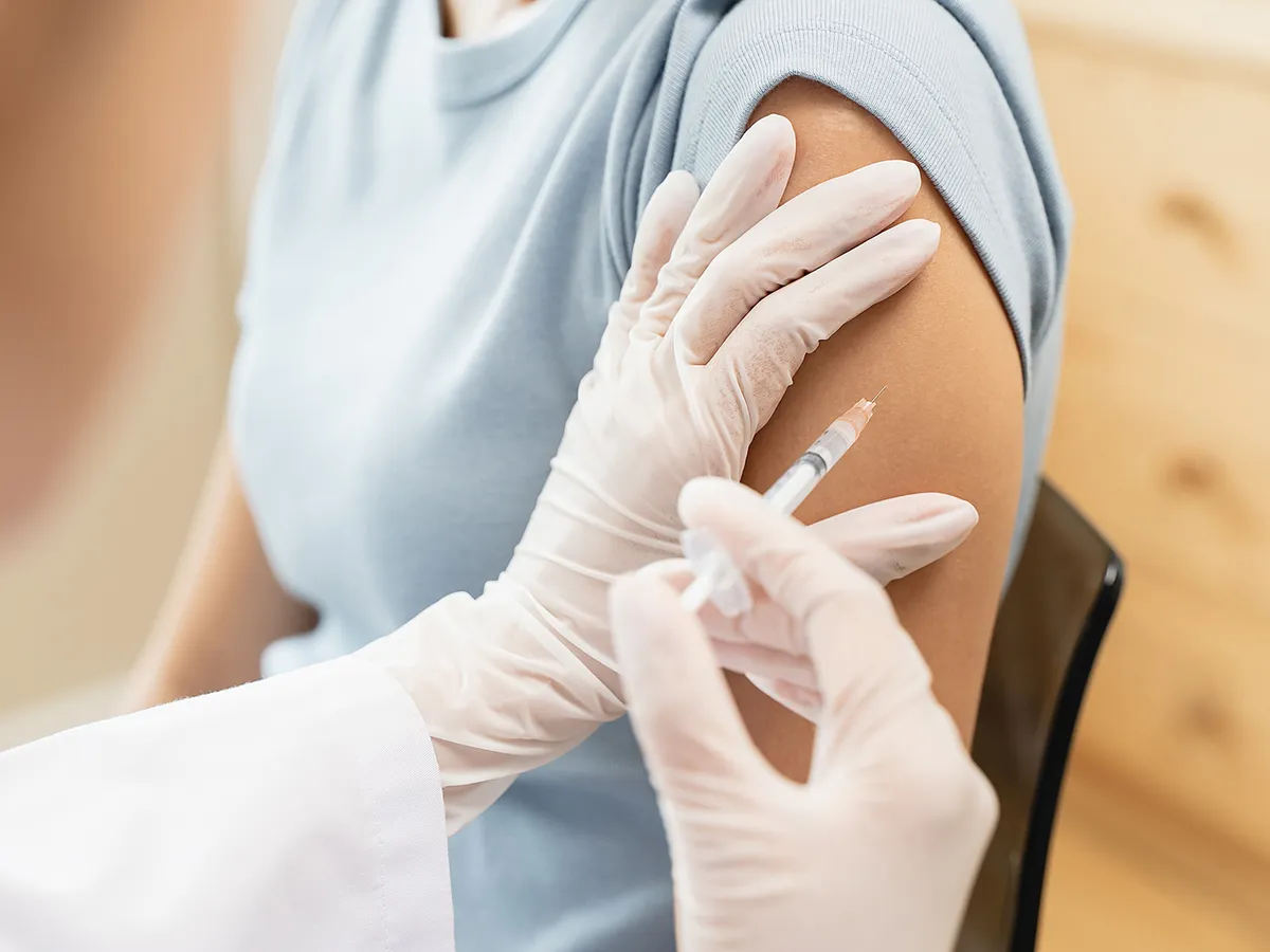 People getting a vaccination to prevent pandemic concept. Woman in medical face mask  receiving a dose of immunization coronavirus vaccine from a nurse at the medical center hospital