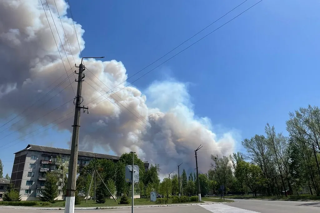 This handout photograph, taken and released by the Ukrainian Chernobyl Radiation and Ecological Biosphere Reserve on May 8, 2026, shows smoke billowing over buildings in the town of Chernobyl from a forest fire in the Chernobyl Exclusion Zone in northern Ukraine amid the Russian invasion of Ukraine. A large forest fire was burning through the Chernobyl exclusion zone on May 8, 2026, following a drone crash near the defunct nuclear plant the previous day, Ukrainian authorities said. (Photo by Handout / Ukrainian Chernobyl Radiation and Ecological Biosphere Reserve / AFP) / RESTRICTED TO EDITORIAL USE - MANDATORY CREDIT "AFP PHOTO / Ukrainian Chernobyl Radiation and Ecological Biosphere Reserve" - NO MARKETING NO ADVERTISING CAMPAIGNS - DISTRIBUTED AS A SERVICE TO CLIENTS