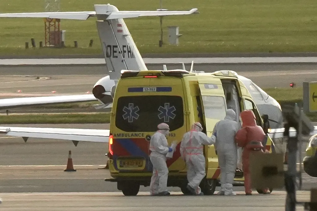 A person in a hazmat suit (2R) is escorted to a ambulance from a medical aircraft allegedly carrying some of the passengers from the cruise ship MV Hondius believed to be infected with hantavirus, at Schiphol airport near Amsterdam on May 6, 2026. A plane that left Cape Verde following the evacuation of a cruise ship hit by the hantavirus landed in Spain's Canary Islands on May 6, while a second flight headed for the Netherlands. (Photo by Lina Selg / AFP)