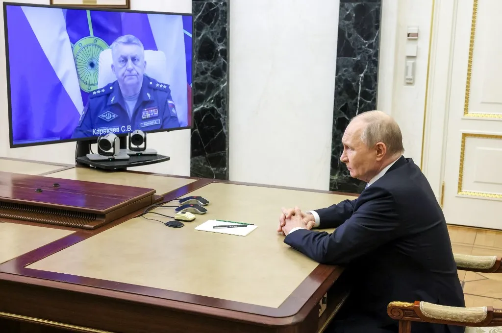 In this pool photograph distributed by the Russian state agency Sputnik, Russia's President Vladimir Putin holds a videolinked meeting with the country's missile forces commander, Sergei Karakayev, on the successful test launch of the Sarmat heavy liquid-fueled intercontinental ballistic missile, in Moscow on May 12, 2026. (Photo by Mikhail METZEL / POOL / AFP)