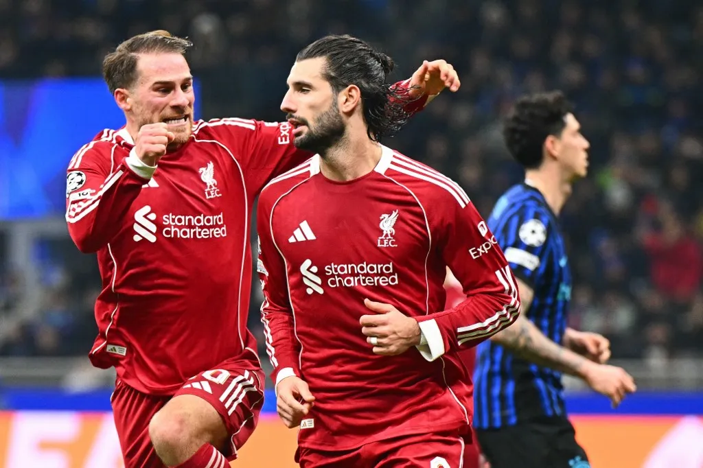 Liverpool's Hungarian midfielder #08 Dominik Szoboszlai celebrates scoring a penalty kick with Liverpool's Argentinian midfielder #10 Alexis Mac Allister during the UEFA Champions League phase day 6 football match between Inter Milan and Liverpool at San Siro stadium in Milan, on December 9, 2025. (Photo by Stefano RELLANDINI / AFP)