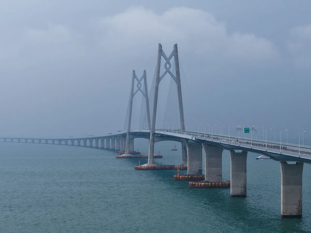 (241124) -- ZHUHAI, Nov. 24, 2024 (Xinhua) -- This aerial photo shows cyclists competing across the Hong Kong-Zhuhai-Macao Bridge during the 2024 Guangdong-Hong Kong-Macao Road Cycling Race and the test event for China's 15th National Games in Zhuhai, south China's Guangdong Province, Nov. 24, 2024. (Xinhua/Liu Dawei) (Photo by Liu Dawei / Xinhua via AFP)