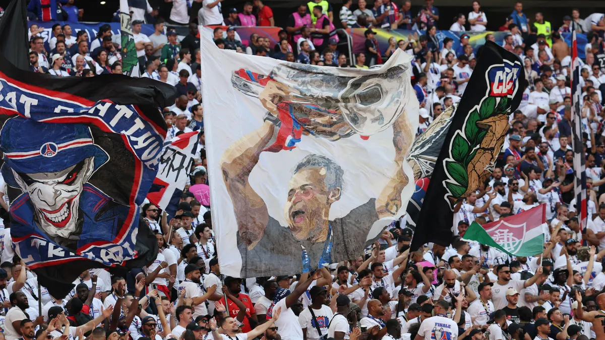 PSG supporters wave a large flag (C) from the stands with an image of Paris Saint-Germain's Spanish head coach Luis Enrique before the the UEFA Champions League final football match between Paris Saint-Germain (PSG) and Arsenal FC at the Puskas Arena in Budapest on May 30, 2026. (Photo by FRANCK FIFE / AFP)