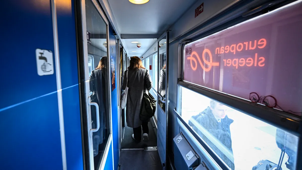 Passengers walk in the first night train operated by the Dutch-Belgian railway cooperative European Sleeper, which runs the Paris-Berlin line, as it departs from Gare du Nord in Paris, on March 26, 2026. (Photo by JULIEN DE ROSA / AFP)