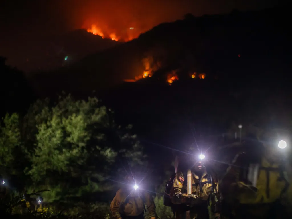 Erdőtűz, Kalifornia, ErdőtűzKalifornia, 2026.05.19., Firefighters walk back to their fire truck as the Sandy Fire continues to burn in the hills of Simi Valley, California on May 18, 2026. A brush fire broke out May 18 in the suburbs of Los Angeles, spre