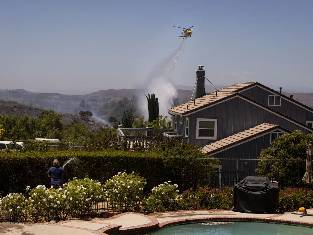 Erdőtűz, Kalifornia, ErdőtűzKalifornia, 2026.05.19., Simi Valley, 2026. május 19.
Vizet dob le egy helikopter a lángoló növényzetre a kaliforniai Simi Valley településnél 2026. május 18-án, amikor erdőtüzek pusztítanak Kalifornia déli részén.
MTI/AP/Etha