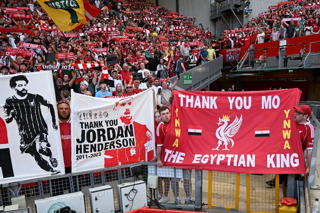 Fans hold tributes to Jordan Henderson and Liverpool's Egyptian striker #11 Mohamed Salah ahead of the English Premier League football match between Liverpool and Brentford at Anfield in Liverpool, north west England on May 24, 2026. (Photo by Paul ELLIS / AFP) / RESTRICTED TO EDITORIAL USE. No use with unauthorized audio, video, data, fixture lists, club/league logos or 'live' services. Online in-match use limited to 120 images. An additional 40 images may be used in extra time. No video emulation. Social media in-match use limited to 120 images. An additional 40 images may be used in extra time. No use in betting publications, games or single club/league/player publications. /