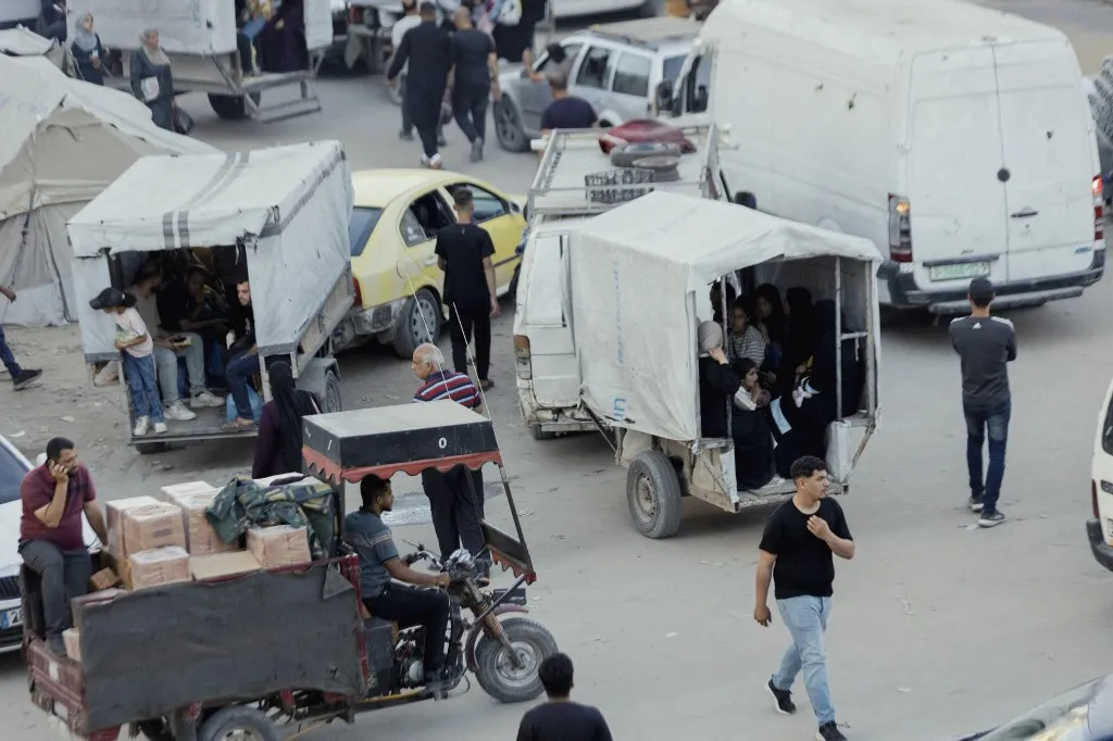 Palestinians travel in makeshift passenger carts attached to vehicles along a street in Gaza City on May 24, 2026. Restrictions on the entry of vehicle spare parts and maintenance equipment under Israels blockade of the Gaza Strip have pushed transportation services deeper into crisis. Extensive damage caused by Israeli attacks and continuing fuel shortages have forced residents to improvise alternative means of transport across the city. (Photo by Ahmed Al Arini / Middle East Images via AFP)