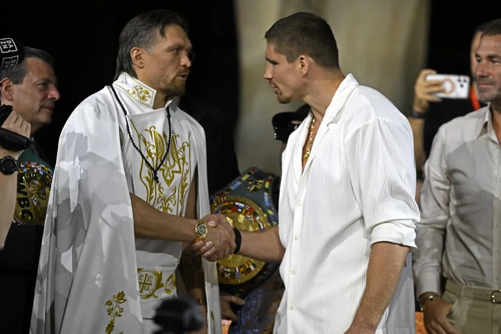Ukraine's Oleksandr Usyk (L) shakes hands with Netherlands' Rico Verhoeven during a press conference at the Grand Egyptian Museum in Giza on May 21, 2026, ahead of their WBC World Heavyweight Championship 'Glory in Giza' boxing match in Egypt. (Photo by Khaled DESOUKI / AFP)