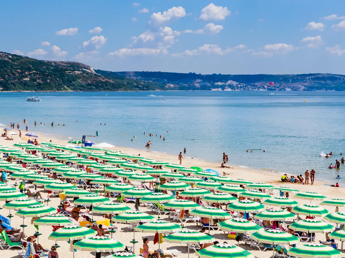The Black Sea shore, blue clear water, beach with sand, umbrellas and sunbeds. Albena, Bulgaria