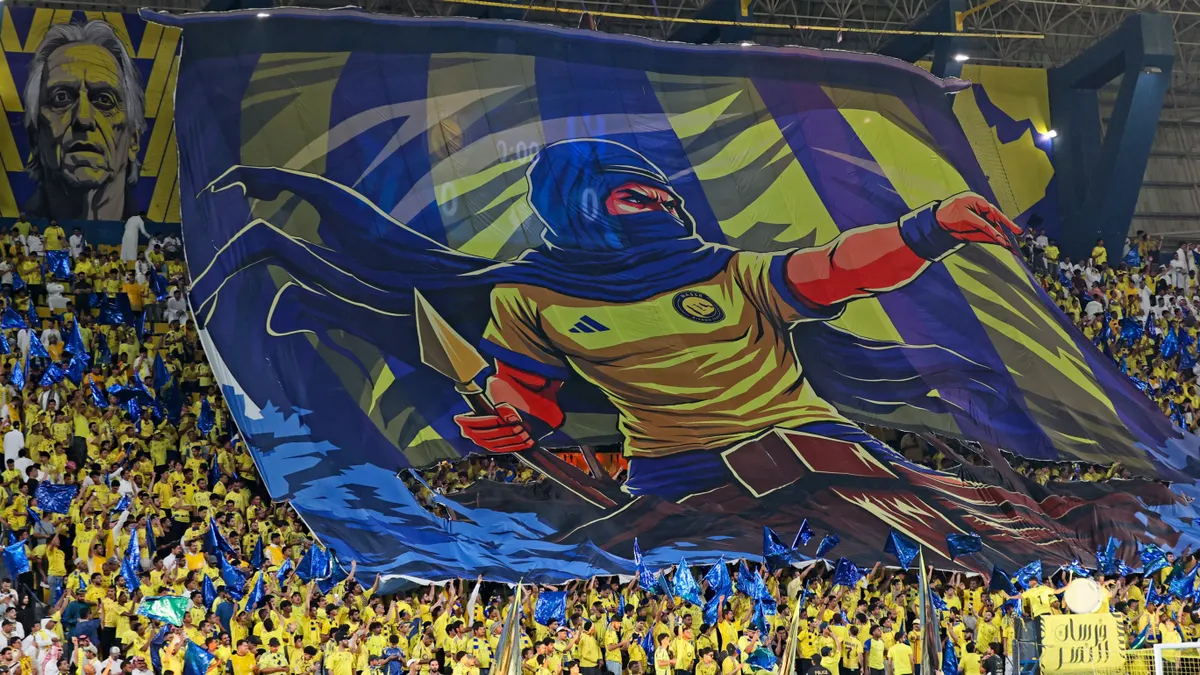 Fans wave a banner during the Saudi Pro League football match between Al-Nassr and Al-Hilal at King Fahd Sports City Stadium in Riyadh on May 12, 2026. (Photo by Fayez NURELDINE / AFP)