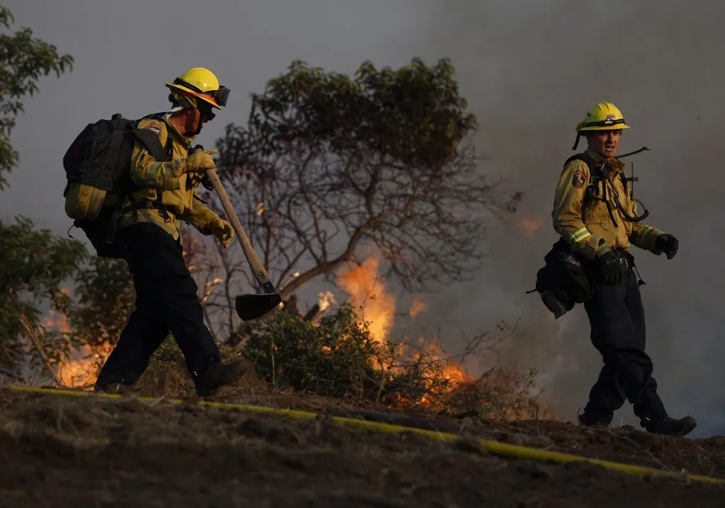 Több tízezer embert evakuáltak Dél-Kaliforniában, ahol Simi Valley mellett és a Santa Rosa-szigeten is pusztít az erdőtűz. - SIMI VALLEY, CALIFORNIA - MAY 18: Cal Fire firefighters battle the Sandy Fire on May 18, 2026 in Simi Valley, California. The fast-moving Sandy Fire burned more than 1,300 acres near Simi Valley and prompted mandatory evacuation orders as strong winds pushed flames toward homes and nearby communities. The fire has destroyed one home. Justin Sullivan/Getty Images/AFP (Photo by JUSTIN SULLIVAN / GETTY IMAGES NORTH AMERICA / Getty Images via AFP)