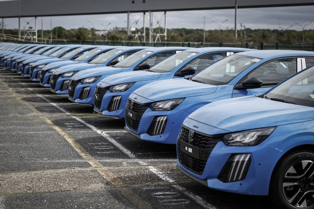 Peugeot cars are seen parked outside the Stellantis multinational car manufacturer's plant in Poissy, west of Paris, on April 15, 2026. Automaker Stellantis will cease automobile production at its historic Poissy plant (Yvelines) after 2028. The site will be converted into a parts manufacturing and vehicle dismantling center, retaining 1,000 of the current 2,000 jobs, the group announced on April 16, 2026. (Photo by Simon Wohlfahrt / AFP), Új Peugeot modellek sorakoznak a Stellantis Párizs melletti telepén Poissy-ben