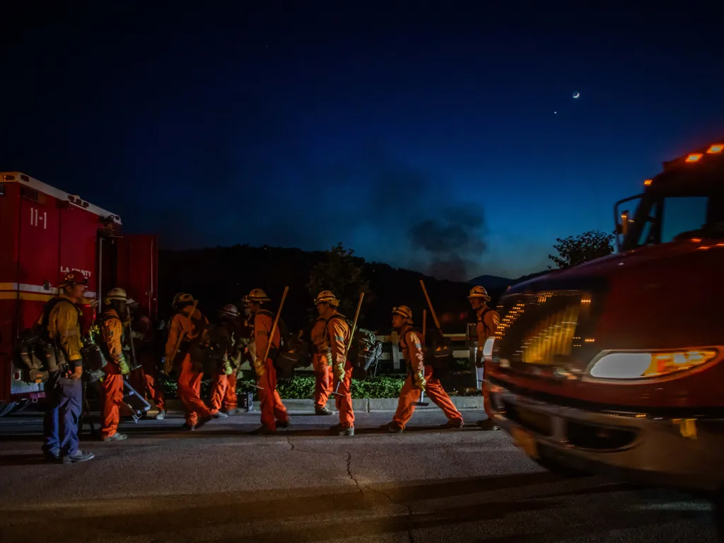 Erdőtűz, Kalifornia, ErdőtűzKalifornia, 2026.05.19., Inmate firefighters walk back to their fire truck after combating the Sandy Fire in Simi Valley, California on May 18, 2026. A brush fire broke out May 18 in the suburbs of Los Angeles, spreading rapid