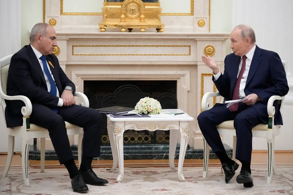 Russian President Vladimir Putin (R) speaks with Armenian Prime Minister Nikol Pashinyan during their meeting at the Kremlin in Moscow, on April 1, 2026. (Photo by Pavel Bednyakov / POOL / AFP)