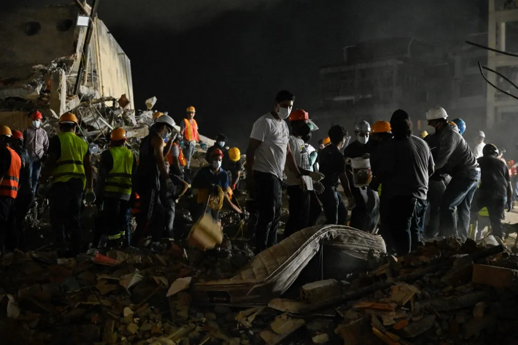 Rescue workers and volunteers search through the rubble of a collapsed building in Caracas on June 25, 2026, following a series of earthquakes. Desperate Venezuelans raced to find and rescue loved ones trapped alive beneath the rubble of collapsed buildings after two major earthquakes, measured at magnitudes 7.2 and 7.5, hit northern Venezuela killing at least 235 people and leaving more than 1,500 injured. (Photo by Maryorin Mendez / AFP)