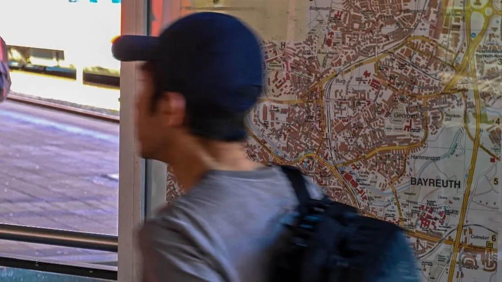 stressz A traveler with a backpack passes a Bayreuth city map in Bayreuth, Bavaria, Germany, on May 1, 2026. Tourism and city maps guide visitors through local attractions, sightseeing routes, and cultural destinations. (Photo by Michael Nguyen/NurPhoto) (Photo by Michael Nguyen / NurPhoto via AFP)