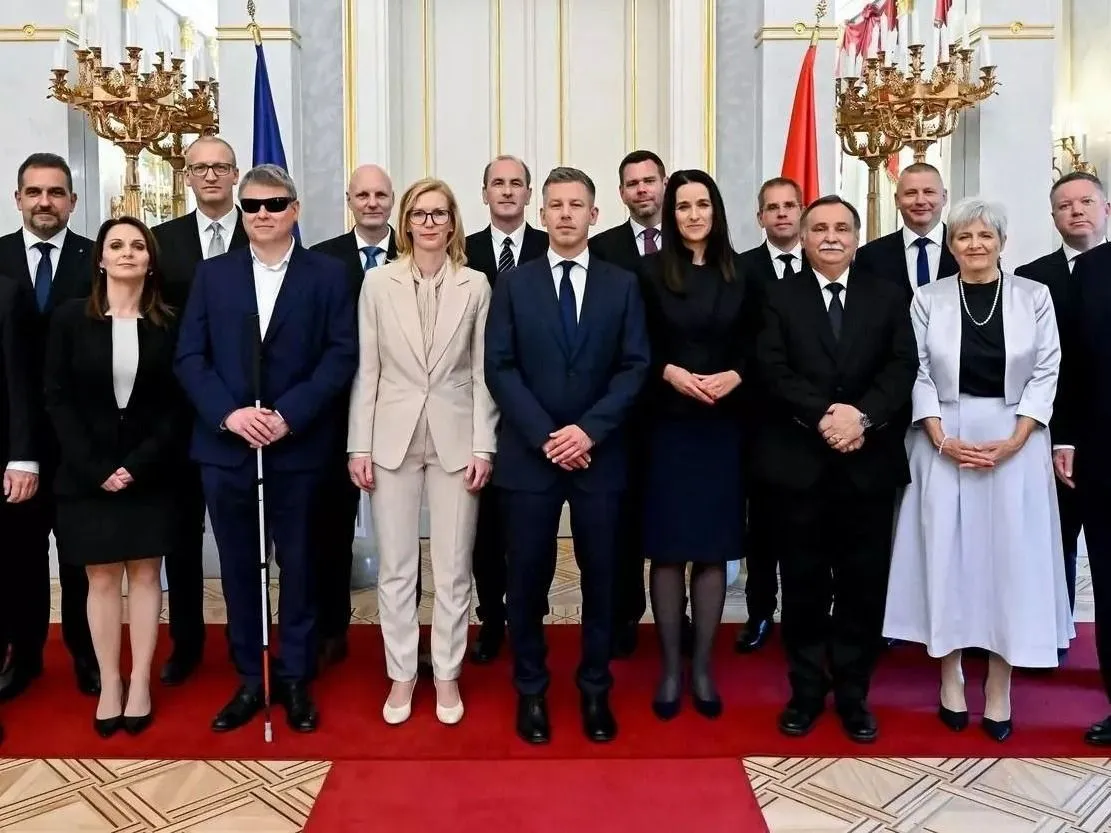 Budapest, 2026. május 12.
A Tisza-kormány miniszterei a kinevezési ünnepségen, középen Magyar Péter miniszterelnök a Sándor-palotában 2026. május 12-én. Az első sorban Kármán András pénzügyminiszter (b), Lőrincz Viktória vidék- és településfejlesztési miniszter (b2), Kátai-Németh Vilmos szociális- és családügyi miniszter (b3), Görög Márta igazságügyi miniszter (b4), Orbán Anita külügyminiszter (j4), Gajdos László élő környezetért felelős miniszter (j3), Lannert Judit oktatási és gyermekügyi miniszter (j2) és Kapitány István gazdasági és energetikai miniszter (j). A második sorban balról jobbra: Bóna Szabolcs agrár- és élelmiszergazdasági miniszter, Tarr Zoltán társadalmi kapcsolatokért és kultúráért felelős miniszter, Tanács Zoltán tudományos és technológiai miniszter, Hegedűs Zsolt egészségügyi miniszter, Vitézy Dávid közlekedési és beruházási miniszter, Ruff Bálint, a Miniszterelnökséget vezető miniszter, Ruszin-Szendi Romulusz honvédelmi miniszter és Pósfai Gábor belügyminiszter. Sulyok Tamás köztársasági elnök adta át a kormány tizenhat miniszterének megbízólevelét.
MTI/Hegedüs Róbert