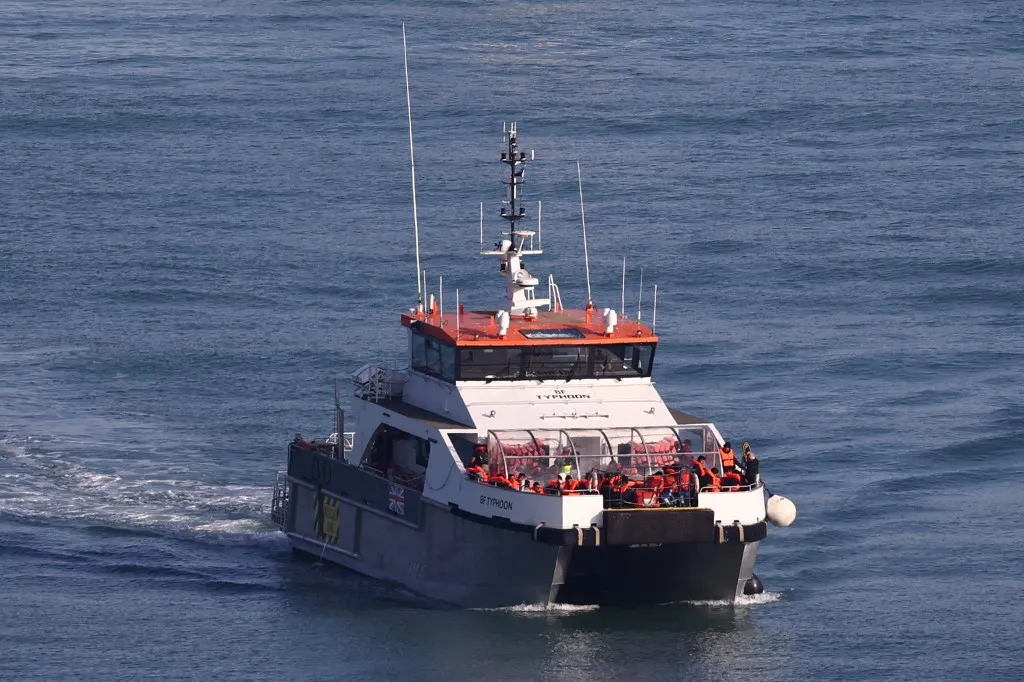 A migráns elfogását a doveri kikötő rendőrei rögzítették A Border Force vessel arrives at the Marina in Dover, south-east England, on September 19, 2025 carrying migrants picked up at sea attempting to cross the English Channel from France. The first migrant was returned to France on September 18 under the new deal allowing the UK to detain and deport irregular migrants deemed ineligible for asylum. In return, the UK will accept an equal number of migrants from France who can apply for a UK visa via an online platform under the pilot scheme which came into effect August and will run until June 2026. UK media reported that "hundreds" of migrants had set off from France early September 19, attempting to cross the Channel on small boats to the UK. (Photo by HENRY NICHOLLS / AFP)