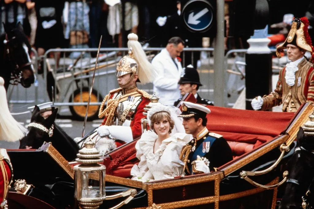 Charles, Prince of Wales, and his bride, Lady Diana, arrive in a carriage at Buckingham Palace on July 29, 1981, after their wedding in St Paul's Cathedral. (Photo by POOL / AFP)