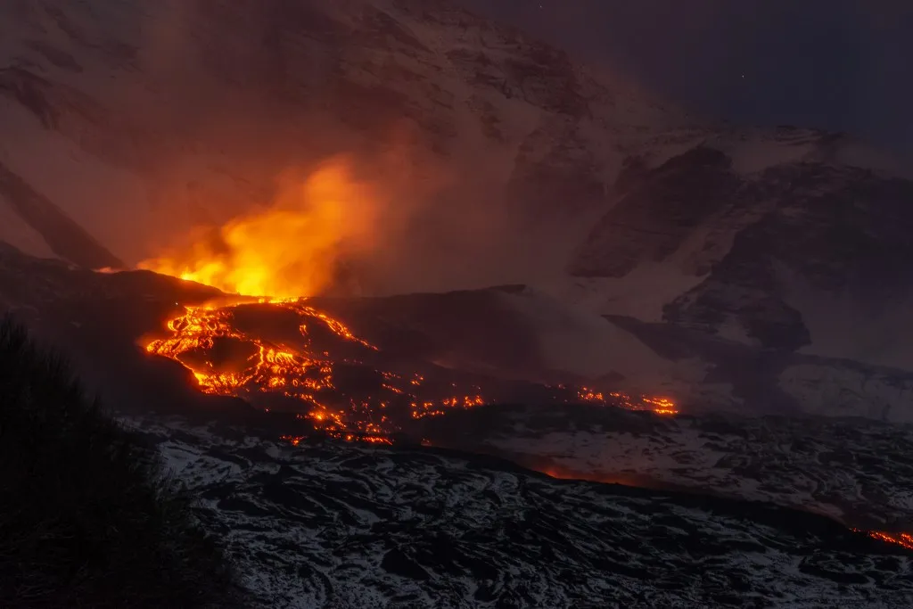 CATANIA, ITALY - JANUARY 02: Volcanic activity continues at Mount Etna after late December 2025 paroxysms at the North-East Crater in Catania, Italy on January 02, 2026. Although explosive activity at the summit has decreased, a new eruptive fissure opens on January 1, 2026, at about 2,000 meters on the volcano’s eastern flank, generating a lava flow into the Valle del Bove. Experts monitor the lateral effusive activity, which remains distant from populated areas and poses no immediate threat. The VONA alert level stays at orange, and Catania International Airport remains fully operational with no impact on air traffic. Photo taken from Zafferana Etnea, near Catania. Salvatore Allegra / Anadolu (Photo by Salvatore Allegra / Anadolu via AFP)