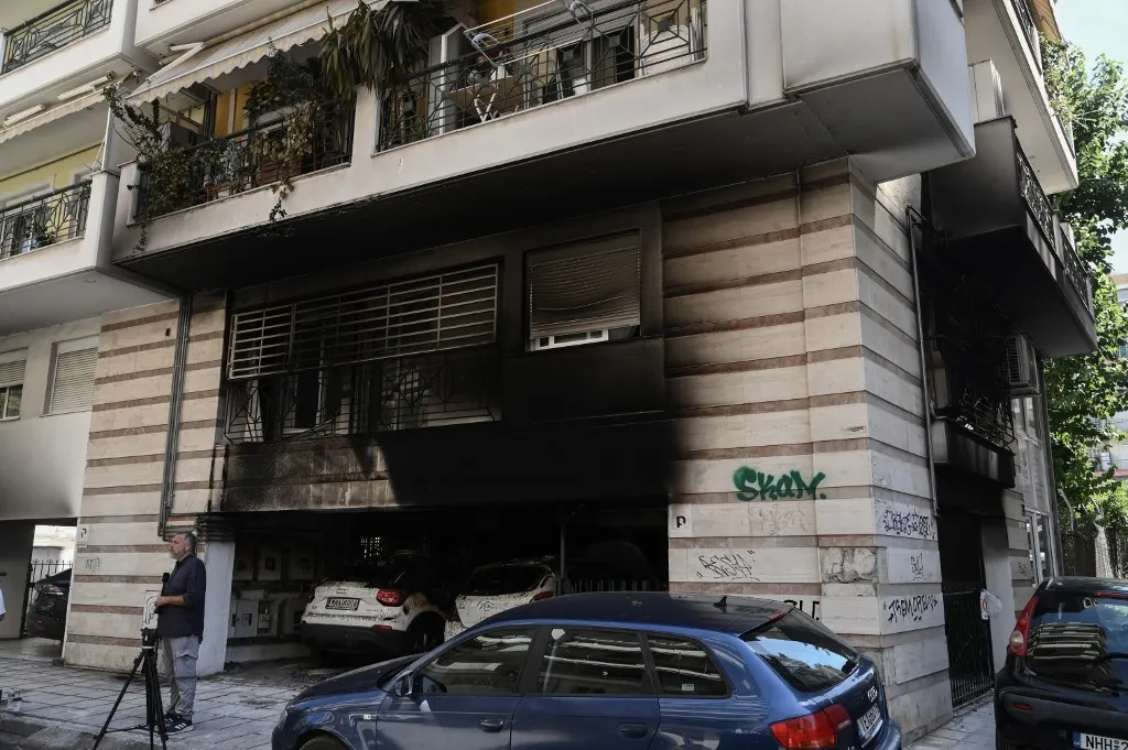 Görögoszág, This photograph shows a view of the damage after a gas canister bomb exploded at the entrance of a building in Thessaloniki on July 1, 2026. Five people were injured and extensive damage was caused by three coordinated incendiary attacks using improvised gas canister bombs targeting the homes of three leaders of Greeces ruling New Democracy party. (Photo by Sakis Mitrolidis / AFP)