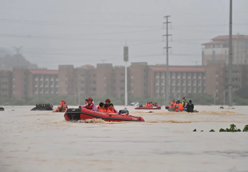 (260708) -- GUIGANG, July 8, 2026 (Xinhua) -- Rescuers evacuate stranded teachers and students at Xijiang education park in Guigang City, south China's Guangxi Zhuang Autonomous Region, July 8, 2026. The torrential rains caused by Typhoon Maysak left many school personnel and students trapped by floods at Xijiang education park in Guigang. Local authorities organized rescue forces to evacuate stranded teachers and students here on Wednesday. (Xinhua/Zhou Hua) (Photo by Zhou Hua / Xinhua via AFP), Maysak trópusi vihar