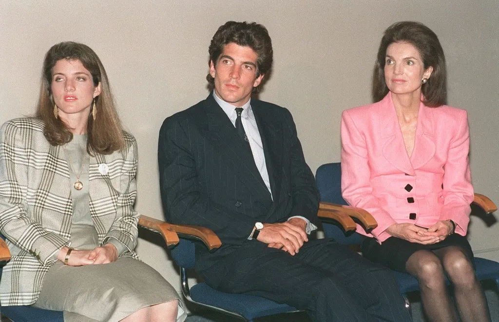 Jacqueline Kennedy Onassis (R) sits with her children Caroline Kennedy Schlossberg (L) and John F. Kennedy Jr (C) during a press conference at the John F. Kennedy Library 25 May in Boston. (Photo by VIN CATAANI / AFP)