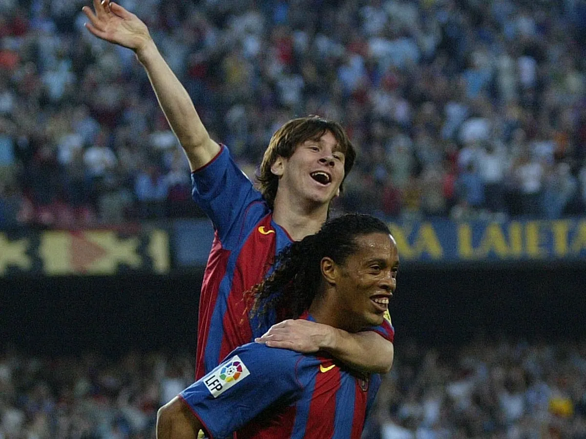 FC Barcelona's Argentinian Messi (up) and Brazilian Ronaldinho celebrate their second goal against Albacete during their Spanish League football match at the Camp Nou stadium in Barcelona, 01 May 2005. FC Barcelona won 2-0. AFP PHOTO/LLUIS GENE. (Photo by LLUIS GENE / AFP)