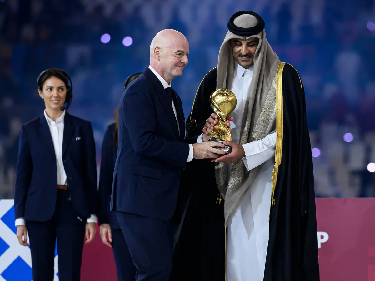 FIFA President Gianni Infantino and Emir of Qatar Sheikh Tamim bin Hamad Al-Thani hold the winner's trophy during the podium ceremony after the FIFA Arab Cup 2025 final match between Jordan and Morocco at Lusail Stadium in Doha, Qatar, on December 18, 2025. (Photo by Noushad Thekkayil/NurPhoto) (Photo by Noushad Thekkayil / NurPhoto via AFP)