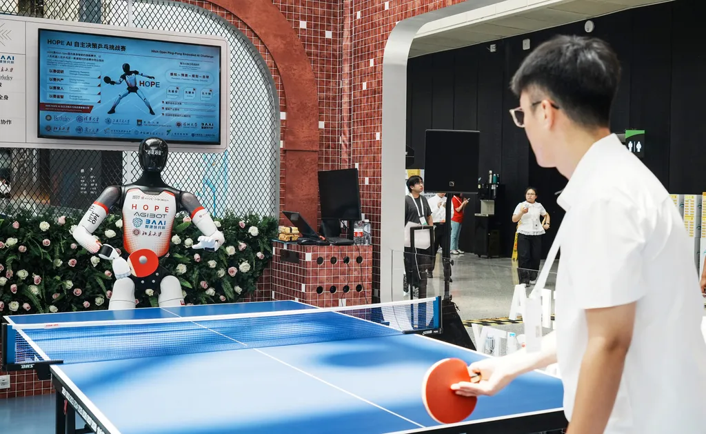A robot (L) plays table tennis with a visitor during the World Artificial Intelligence Conference (WAIC) in Shanghai on July 17, 2026. (Photo by CN-STR / AFP) / China OUT , robot