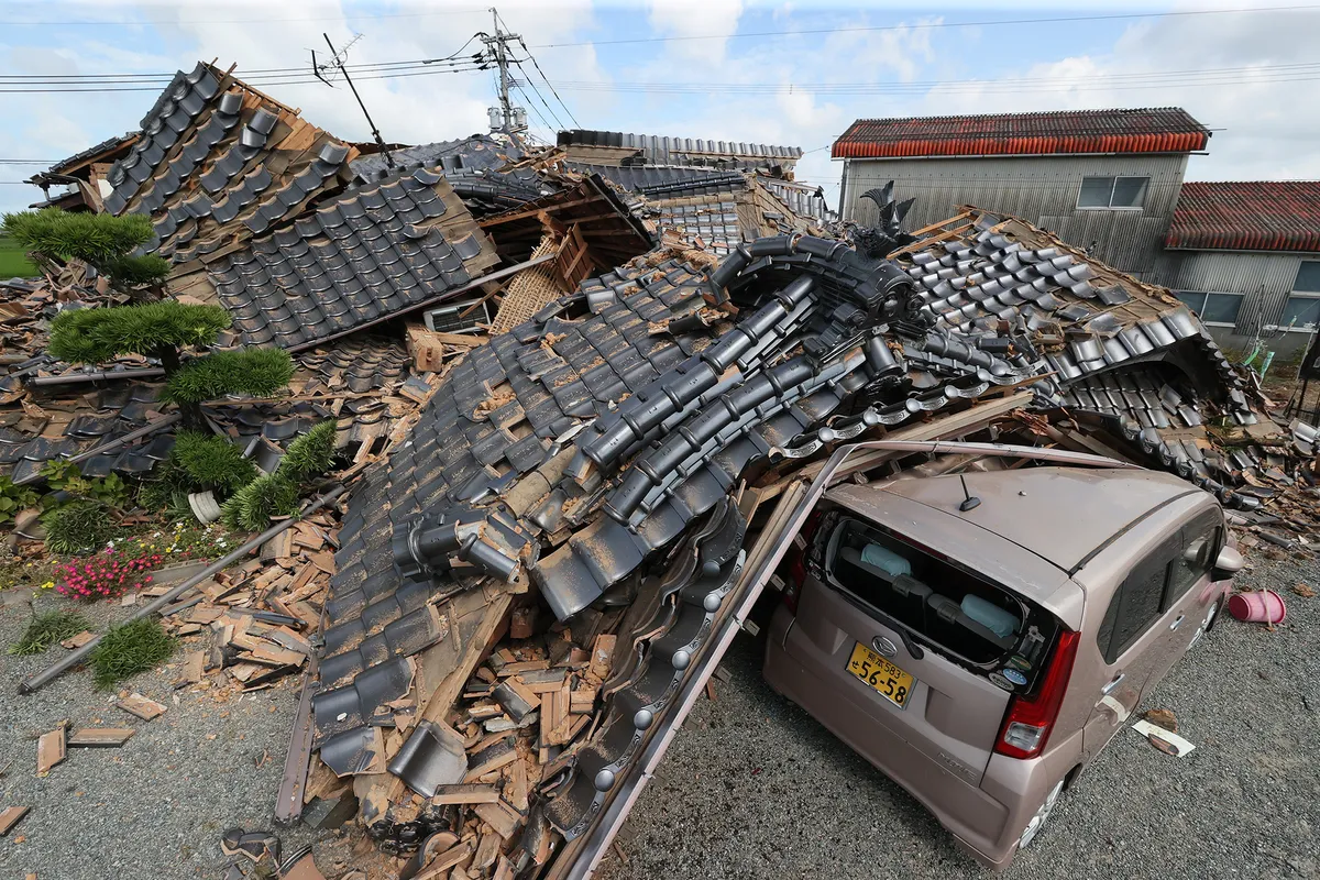 HIKAWA, JAPAN - JULY 29: A car is crumpled by a collapsed house a day after a strong earthquake on July 29, 2026 in Hikawa, Kumamoto, Japan. 3 people dead, 5 in state of cardiopulmonary arrest and 9 are unaccounted for. (Photo by The Asahi Shimbun via Getty Images)