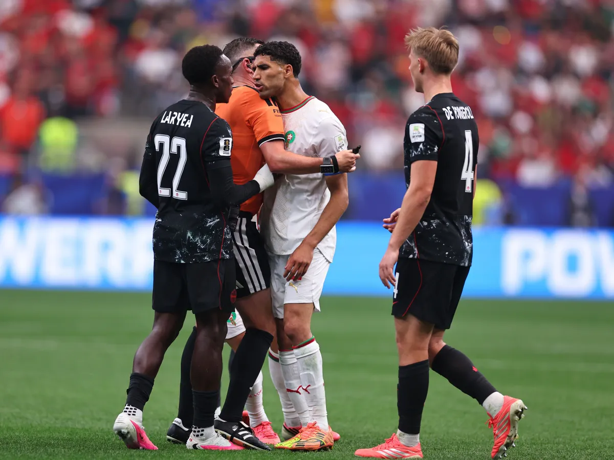 HOUSTON, TEXAS - JULY 04: Referee Michael Oliver intervenes as Achraf Hakimi of Morocco confronts Richie Laryea of Canada during the FIFA World Cup 2026 Round Of 16 match between Canada and Morocco at Houston Stadium on July 04, 2026 in Houston, Texas. (Photo by Robbie Jay Barratt - AMA/Getty Images)