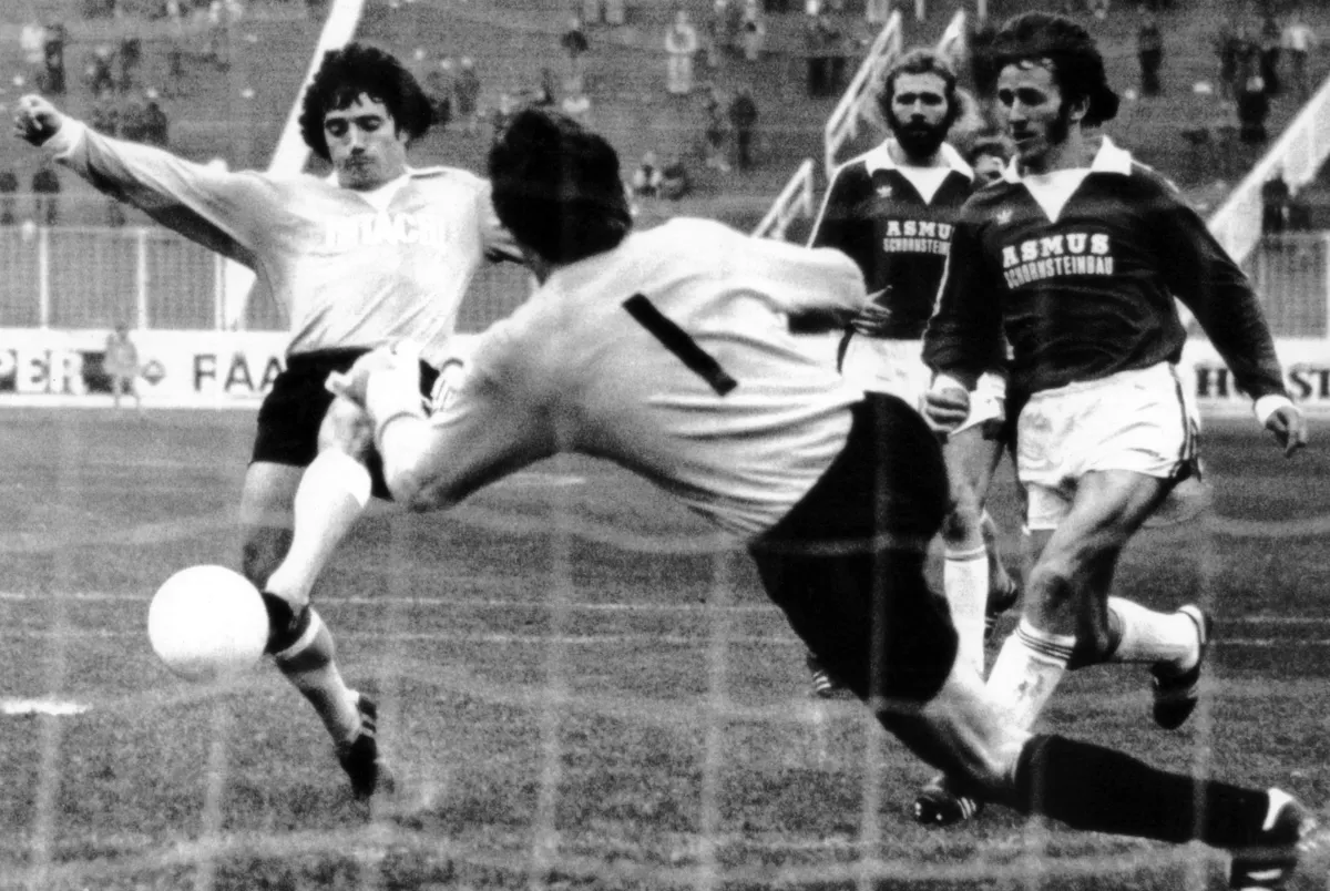 FILED - 15 October 1977, Hamburg: Hamburg's English forward Kevin Keegan (L) scores to give his team a 4-0 lead in the DFB Cup match against VfV Hildesheim. Hildesheim goalkeeper Reichel (center) and his defenders Kaatz (2nd from right) and Aubin (right) are left empty-handed. English soccer legend Keegan has died. The former HSV pro died at the age of 75 from complications related to his cancer, according to the British news agency PA, citing a statement from his family. Photo: picture alliance / dpa (Photo by Heidtmann / dpa Picture-Alliance via AFP)