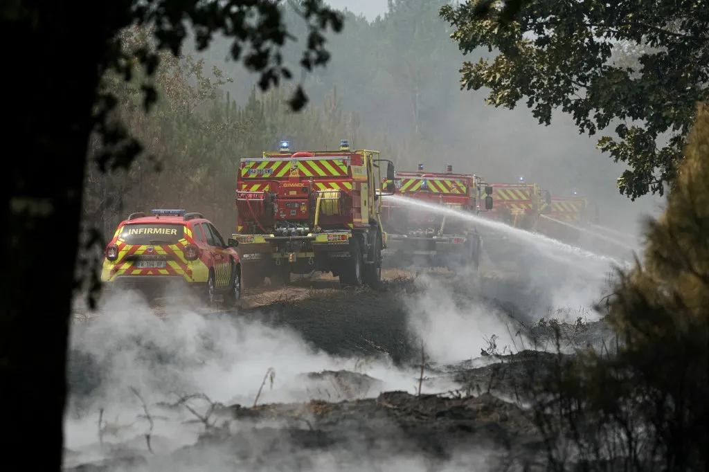 Firefighters carry out mop-up operations, extinguishing remaining hot spots and  smoldering patches, in a forest near Marcheprime, some 30 km from Bordeaux, on July 27, 2026, as a wildfire rages through the forest in Gironde, southwestern France. A massive wildfire in France's Gironde department, home to Bordeaux, remained "broadly stable overnight," the local authority said on July 27, 2026. "The situation remained broadly stable overnight, with no major developments. Security and emergency services remain fully mobilised and are continuing their operations on the ground," the local authority said in a statement. (Photo by Alain JOCARD / AFP)