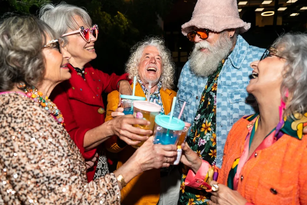 Group of happy senior friends with fancy clothing having party in the night on city streets - Cheerful elderly people  wearing fashionable clothes celebrating and having fun outdoors