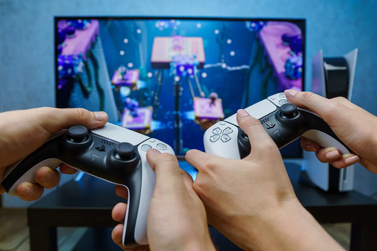 Kaunas, Lithuania - 2021, August 12: Sony PlayStation 5. New generation gaming computer. People playing video games. Couple play play with PS5. Point of view.
