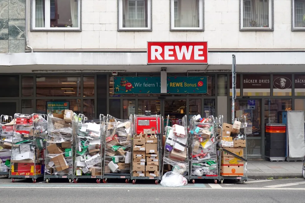 A túszdráma egy berlini Rewe szupermarketben zajlott Packaging waste and cardboard boxes stand outside a REWE supermarket in Wiesbaden, Hesse, Germany, on May 16, 2026. The storefront illustrates aspects of grocery retail, trade logistics, and packaging waste associated with food distribution and environmental concerns. (Photo by Michael Nguyen/NurPhoto) (Photo by Michael Nguyen / NurPhoto via AFP)