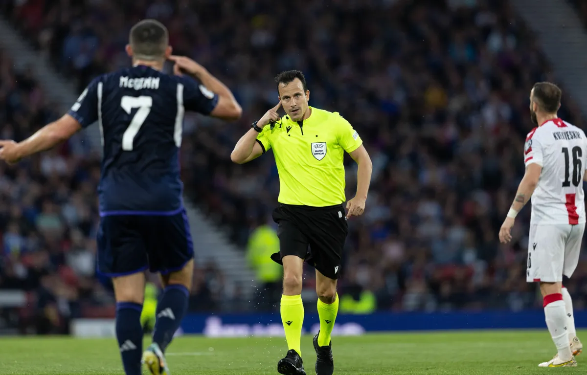 GLASGOW, SCOTLAND - JUNE 20: John McGinn and Referee Istvan Vad  during a UEFA Euro 2024 qualifier between Scotland and Georgia at Hampden Park, on June 20, 2023, in Glasgow, Scotland. (Photo by Craig Foy/SNS Group via Getty Images)