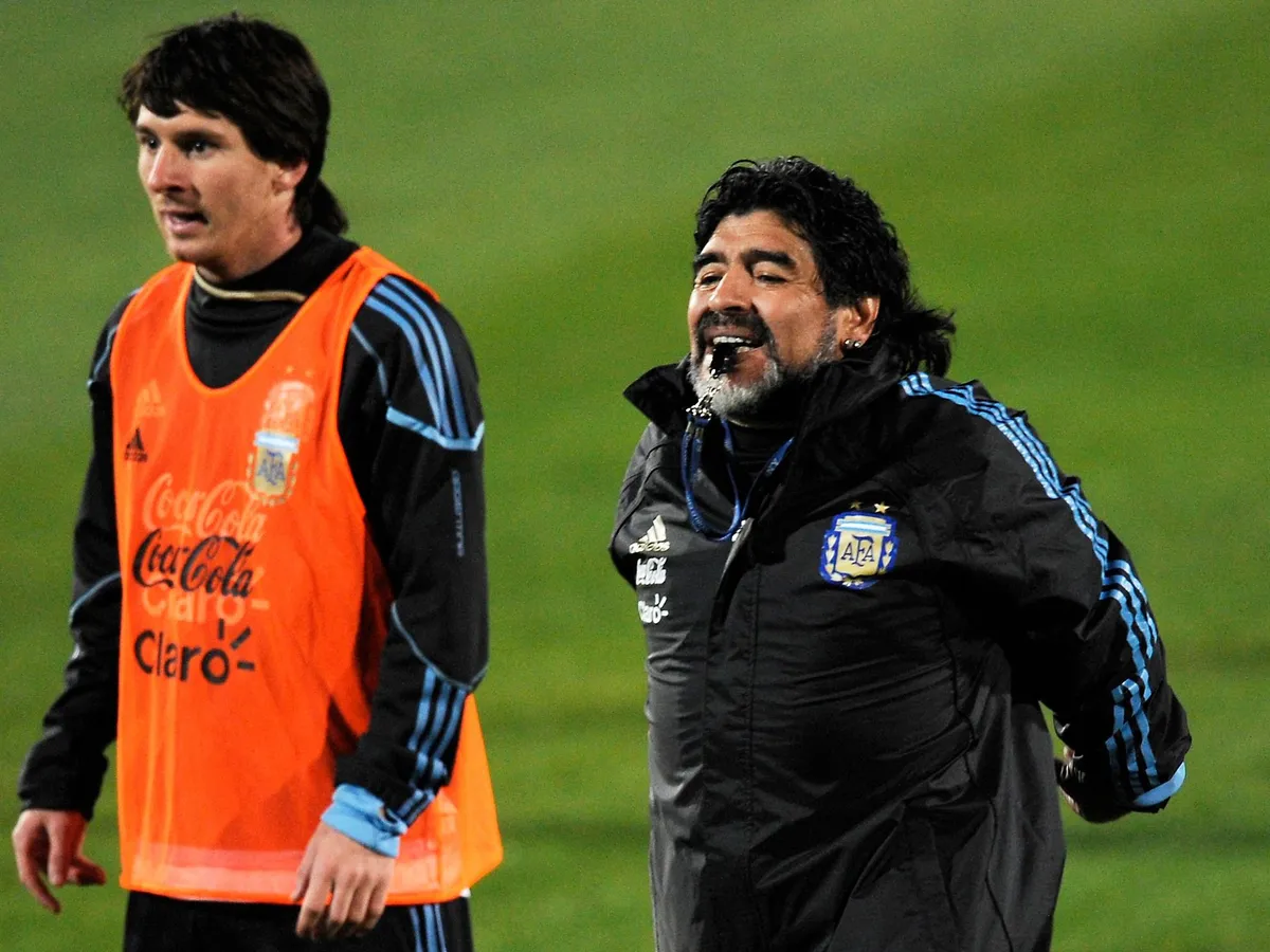 Argentina's coach Diego Maradona (R) blows a whistle as he stands next to forward Lionel Messi during a training session at the University of Pretoria's High Performance Centre on June 8, 2010 ahead of the 2010 World Cup football tournament in South Africa. AFP PHOTO / DANIEL GARCIA (Photo by DANIEL GARCIA / AFP)