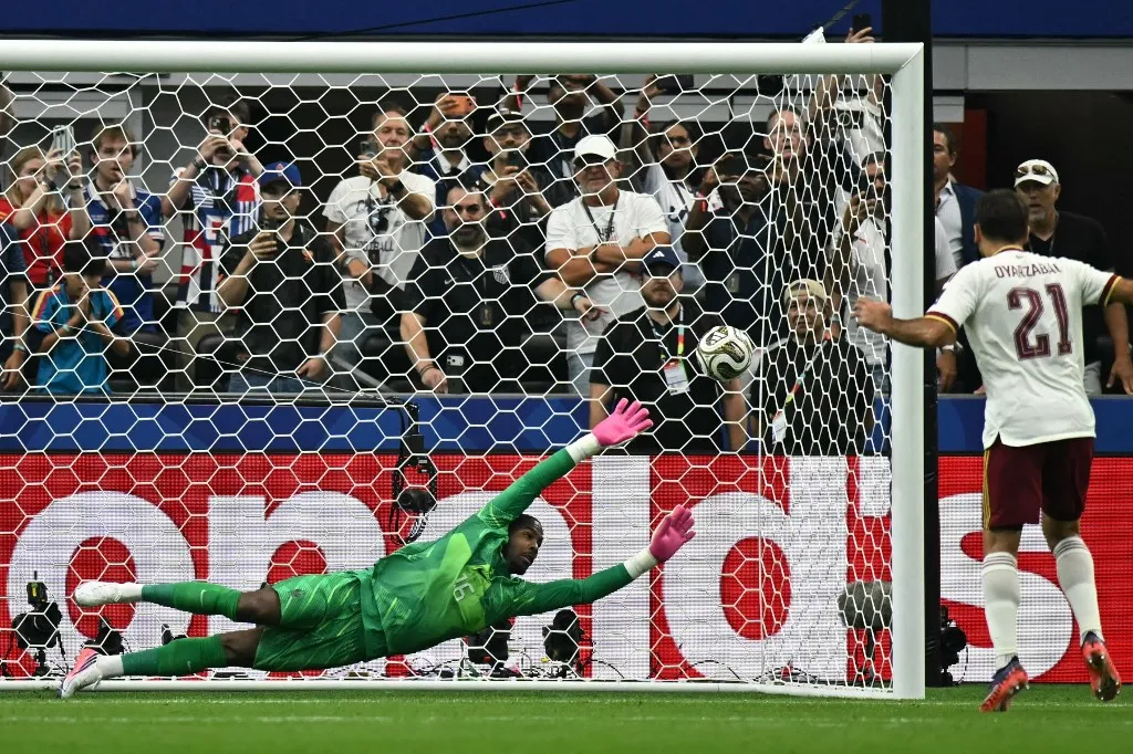 France's goalkeeper #16 Mike Maignan dives in his failed attempt to save the penalty kick off Spain's forward #21 Mikel Oyarzabal during the 2026 World Cup football tournament semi-final match between France and Spain at the Dallas Stadium in Arlington on July 14, 2026.  (Photo by Paul ELLIS / AFP)