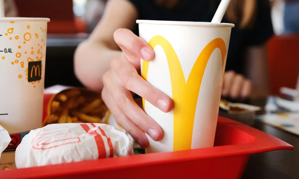 Poznan, Poland - 28 april 2024: Small Girl Sipping Chilled Soda At Mcdonald's Fast Food Joint