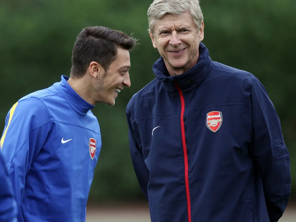 Arsenal's German midfielder Mesut Ozil (L) and Arsenal's French manager Arsene Wenger speak during a training session at the club's complex in London Colney, on September 17, 2013. Arsenal travel to play Olympique Marseille in a UEFA Champions League match Wednesday. AFP PHOTO / ADRIAN DENNIS (Photo by ADRIAN DENNIS / AFP)