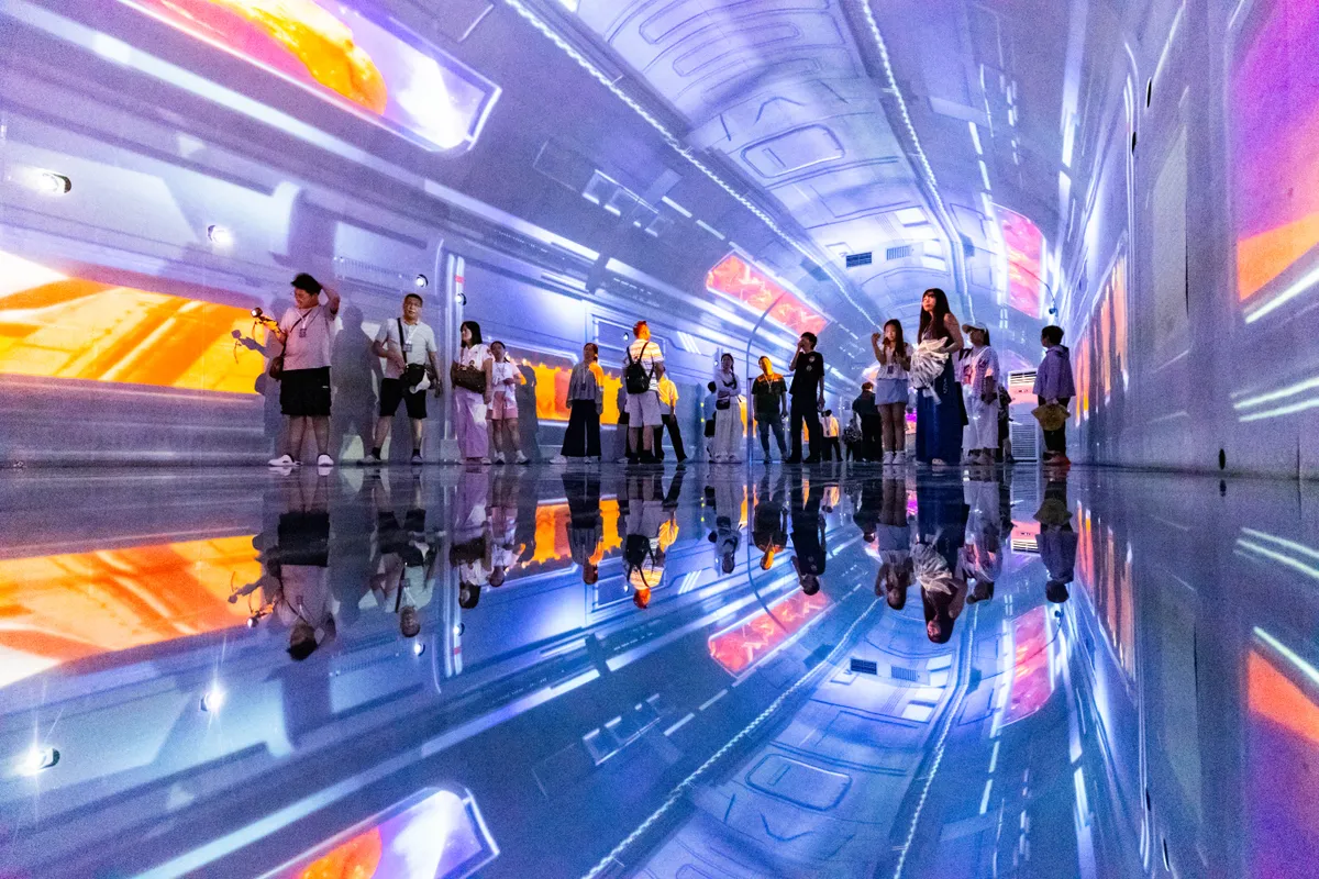 CHONGQING, CHINA - JULY 22: Tourists experience an immersive 'interstellar travel' show via naked-eye 3D screens at the 'Dongjian No.1' theme scenic area in a former air-raid shelter on July 22, 2026 in Chongqing, China. The attraction utilizes digital technology to transform former air-raid shelter into a tourist destination. (Photo by VCG/VCG via Getty Images)