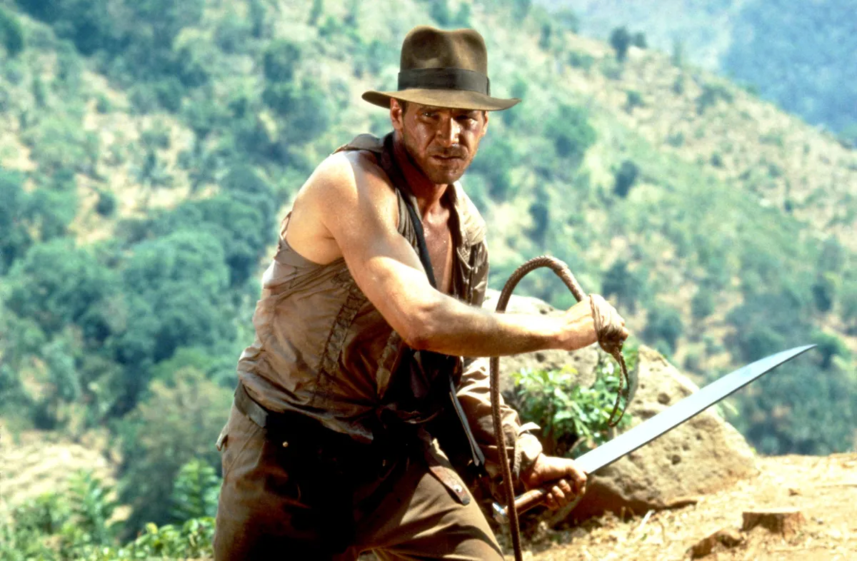 RELEASE DATE: 23 May 1984. MOVIE TITLE: Indiana Jones and the Temple of Doom - STUDIO: Paramount Pictures. PLOT: After arriving in India, Indiana Jones is asked by a desperate village to find a mystical stone. He agrees, and stumbles upon a secret cult plotting a terrible plan in the catacombs of an ancient palace. PICTURED: HARRISON FORD as Indiana Jones.
